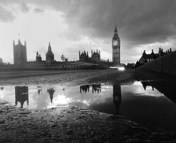 houses of parliament reflected in a puddle