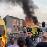 a crowd watch a riot van on fair in Southport