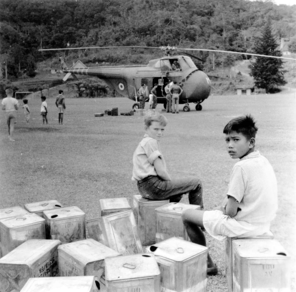 Alastair at a forward airfield in the Cameron Highlands, Malaya watching the deployment of troops and supplies by Wessex helicopter during the Malayan Emergency in 1957.