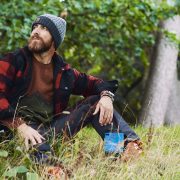 Aldio Kane sat by a tree wearing the Fjӓllrӓven Clothing Range