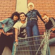 Band Amyl and the Sniffers posing for a photo with lead singer Amy in a shopping trolley