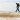 A man walks along a groyne on the beach