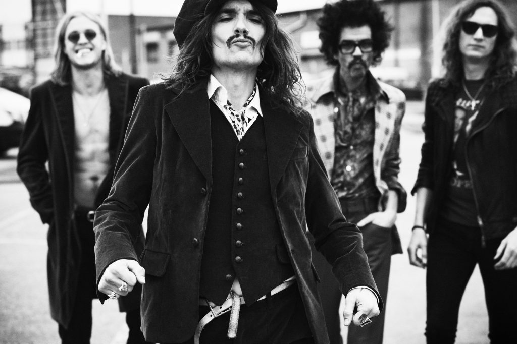 The Darkness pictured with lead singer Justin Hawkins strutting at the front of shot