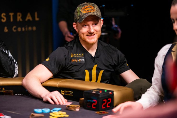 Poker player Jason Koon smiles as he throws chips onto the table