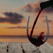 A glass of wine being poured at sunset