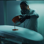 man pouring paint on a surfboard