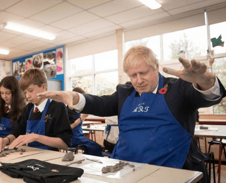 Boris in a classroom playing with clay