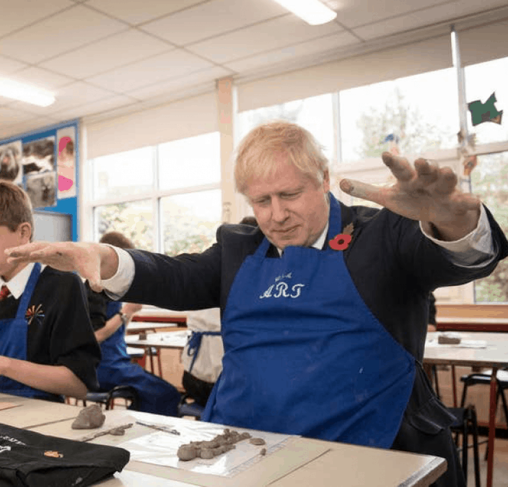 Boris in a classroom playing with clay