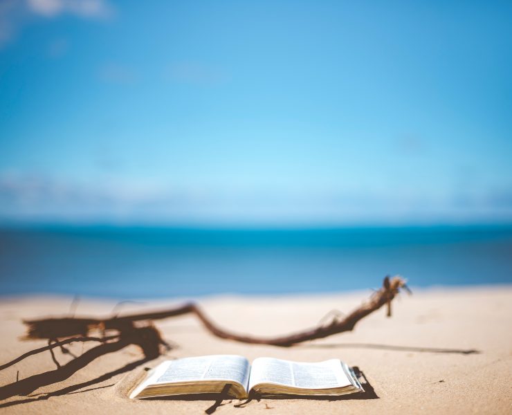 Open book on a beach in front of the ocean