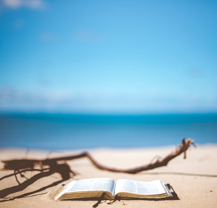Open book on a beach in front of the ocean