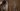 Jean Dujardin looks in a mirror at himself from a scene from Deerskin