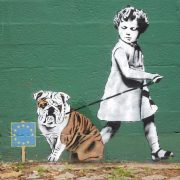 EU graffiti - child trying to lead a bulldog away from eu flag