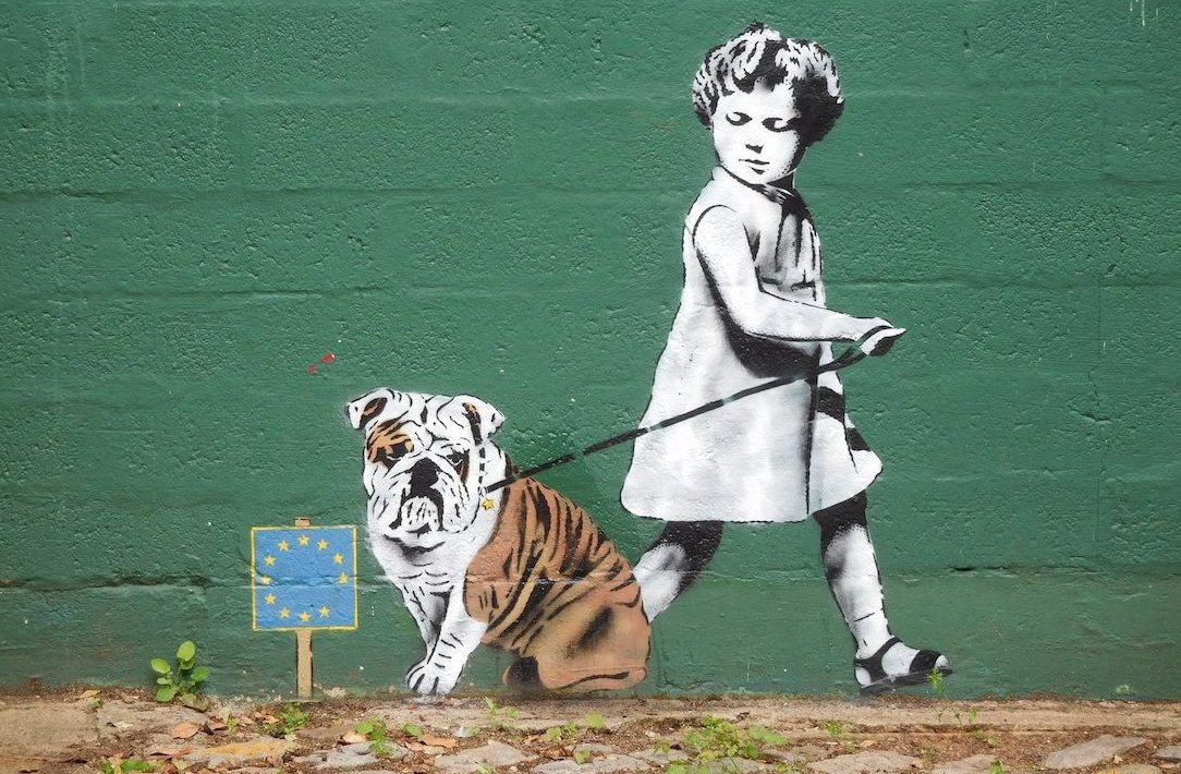 EU graffiti - child trying to lead a bulldog away from eu flag