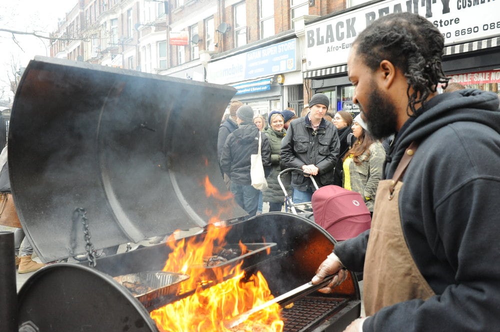 A man cooking meat on a Barbecue grill