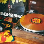 Record player with 77:78 record on it next to headphones