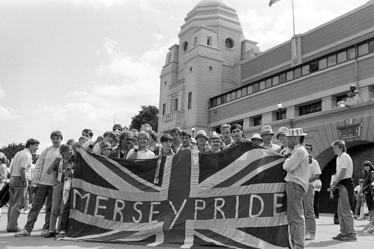 Liverpool fans outside wembley in 80s with flag saying "Merseypride'