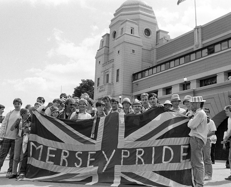 Liverpool fans outside wembley in 80s with flag saying "Merseypride'