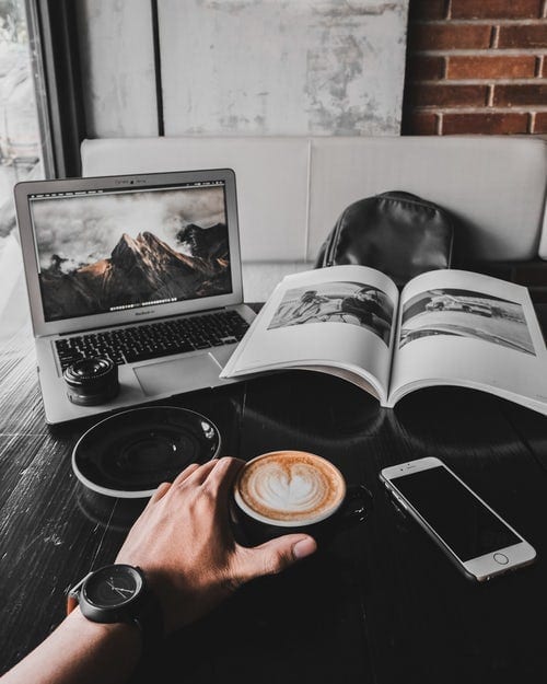 A coffee and laptop on a wooden table