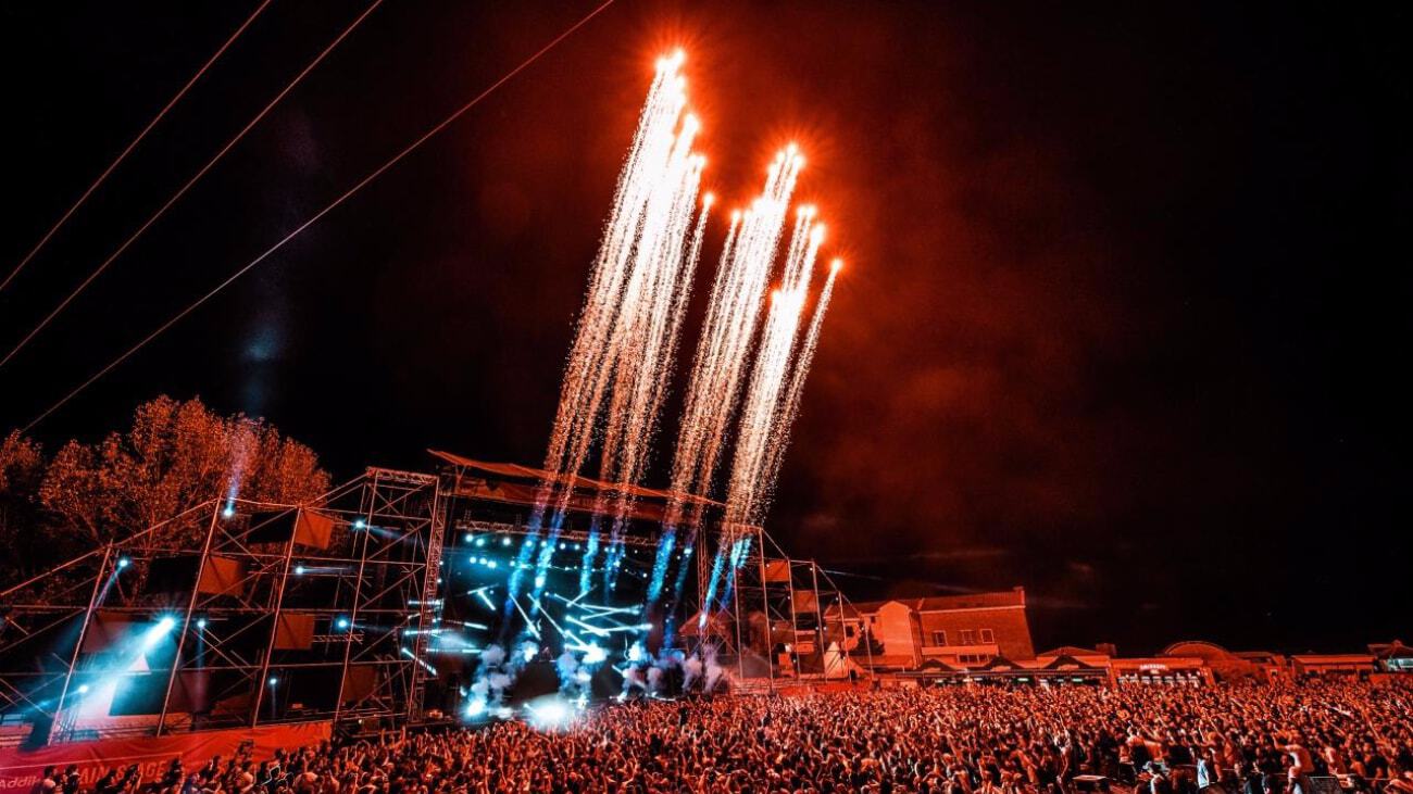 Fireworks blast skywards from an outdoor music stage